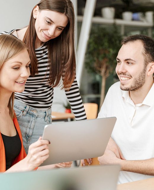Three people reviewing financial information on a tablet